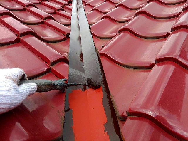 谷板金をローラーで塗装している